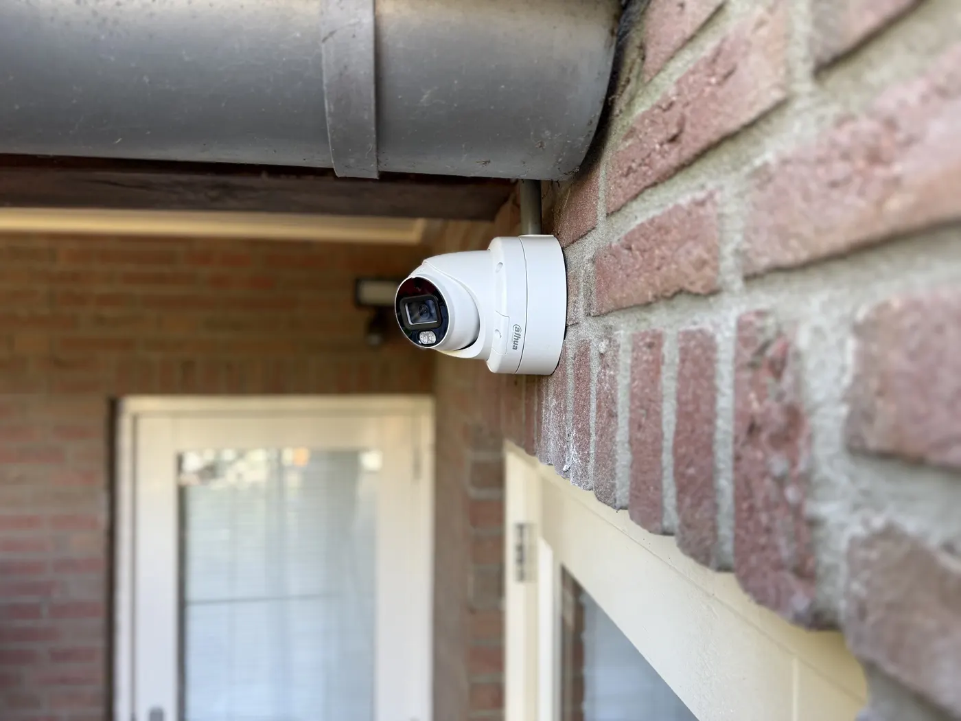 Turret-camera boven de voordeur van een bakstenen woning