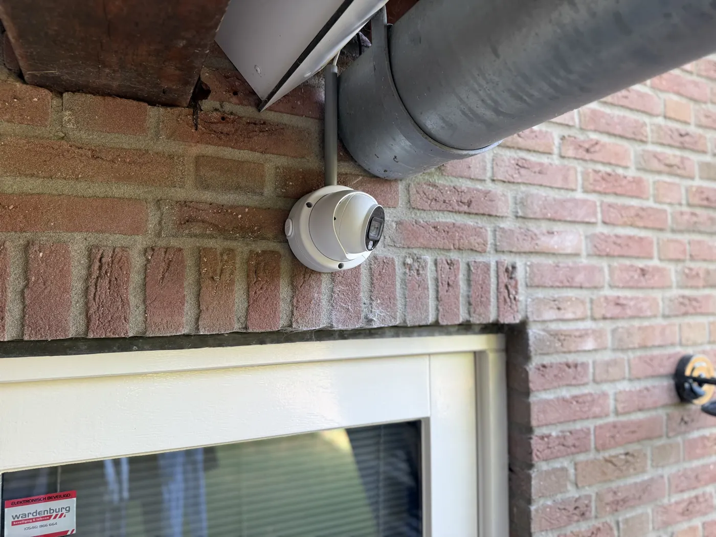 Turret-camera aan de gevel van een woning naast een raam