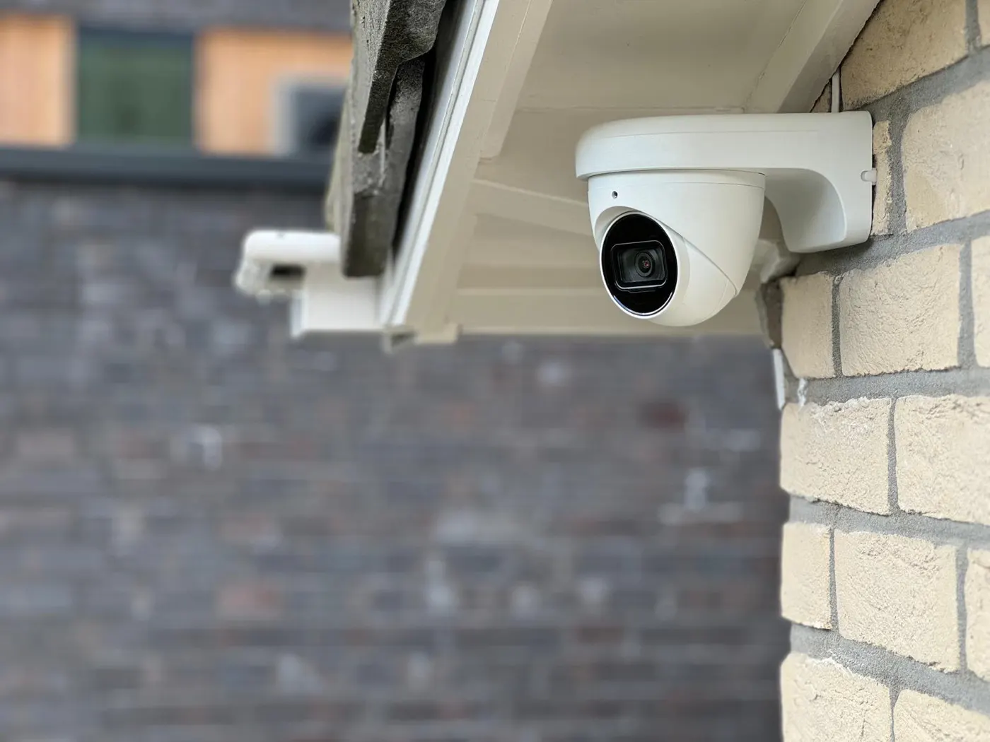 Beveiligingscamera onder de dakrand van een bakstenen woning